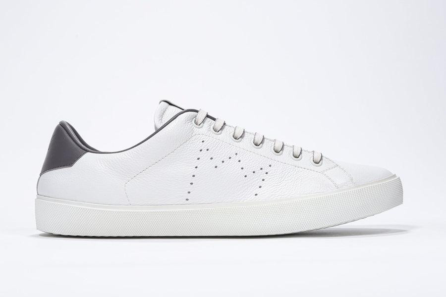 Side profile of low top white sneaker with dark grey detailing and perforated crown logo on upper. Full leather upper and white rubber sole.