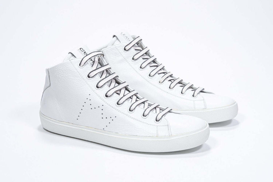 Three quarter view of mid top white sneaker with full leather upper with perforated crown logo and white sole.