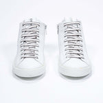 Front view of mid top white sneaker with full leather upper with perforated crown logo and white sole.