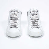 Front view of mid top white sneaker with full leather upper with perforated crown logo and white sole.