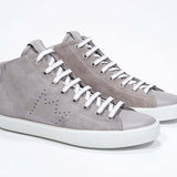 Three quarter front view of mid top beige sneaker with full suede upper with perforated crown logo and white sole.