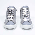 Front view of mid top light grey sneaker with full suede upper with perforated crown logo, internal zip and white sole.
