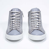 Vue de face du modèle mid top gris clair sneaker à tige entièrement en daim avec logo perforé, fermeture à glissière interne et semelle blanche.