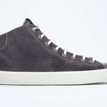 Profilo laterale del mid top grigio scuro sneaker con tomaia interamente in pelle scamosciata con logo della corona traforato, zip interna e suola bianca.