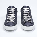 Vista frontale del mid top navy sneaker con tomaia in pelle scamosciata con logo a corona traforato, zip interna e suola bianca.