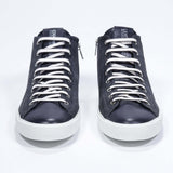 Front view of mid top navy sneaker with full suede upper with perforated crown logo, internal zip and white sole.