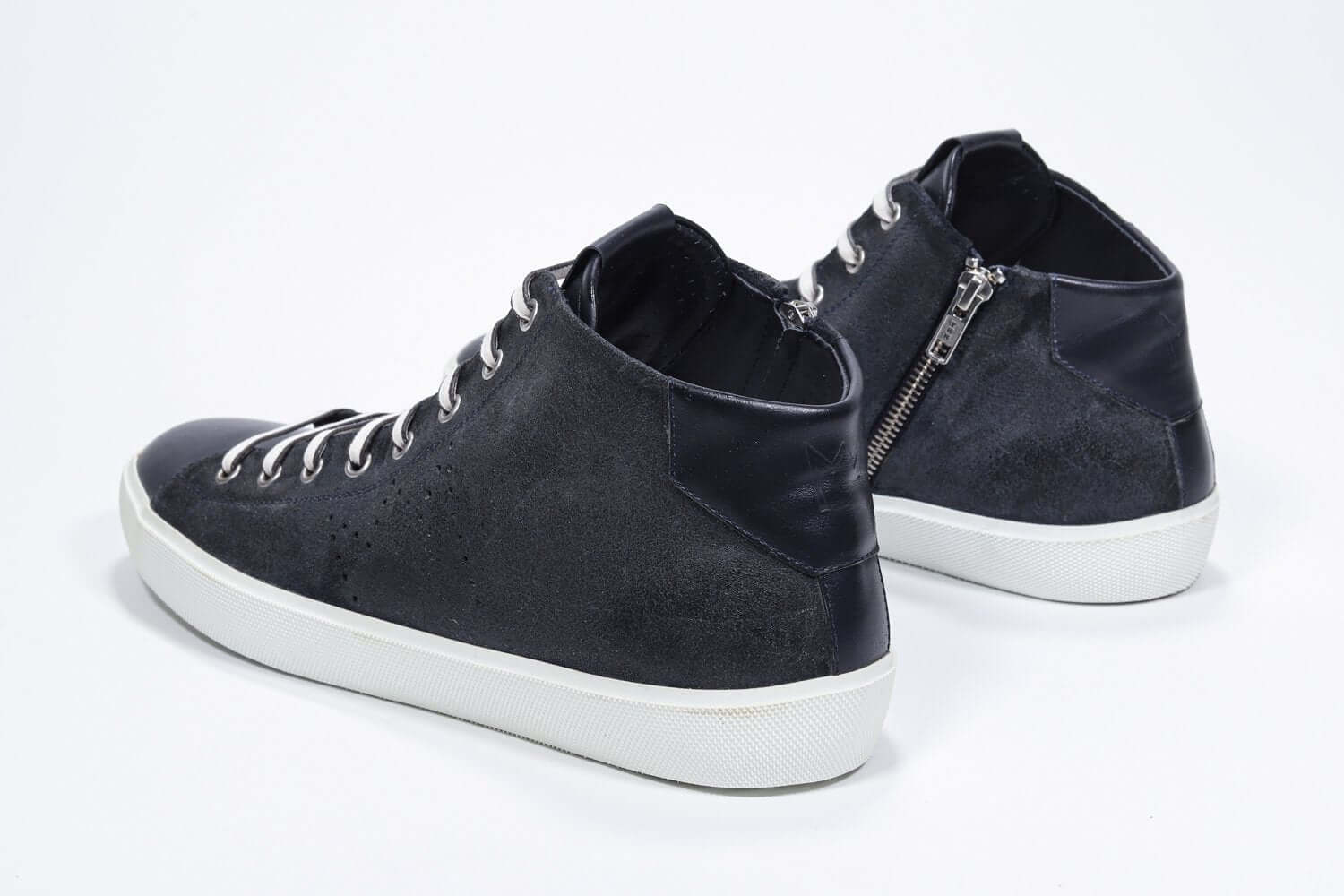 Vista posteriore a tre quarti del modello mid top navy sneaker con tomaia in pelle scamosciata con logo a corona traforato, zip interna e suola bianca.