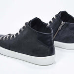 Three quarter back view of mid top navy sneaker with full suede upper with perforated crown logo, internal zip and white sole.