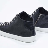 Three quarter back view of mid top navy sneaker with full suede upper with perforated crown logo, internal zip and white sole.