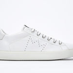 Side profile of low top white sneaker with perforated crown logo on upper. Full leather upper and white rubber sole.