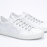 Three quarter front view of low top white sneaker with perforated crown logo on upper. Full leather upper and white rubber sole.