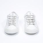 Front view of low top white sneaker with perforated crown logo on upper. Full leather upper and white rubber sole.