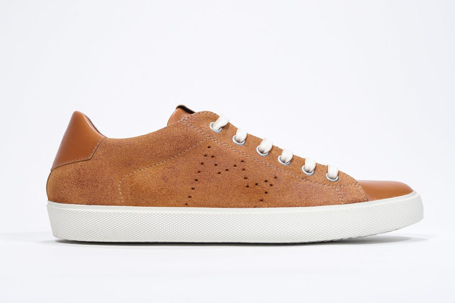 Side profile of low top sneaker with perforated crown logo on upper. Full rust suede upper and white rubber sole.