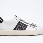 Profilo laterale di BASSE bianco e nero sneaker. Tomaia in pelle con borchie e suola in gomma vintage.