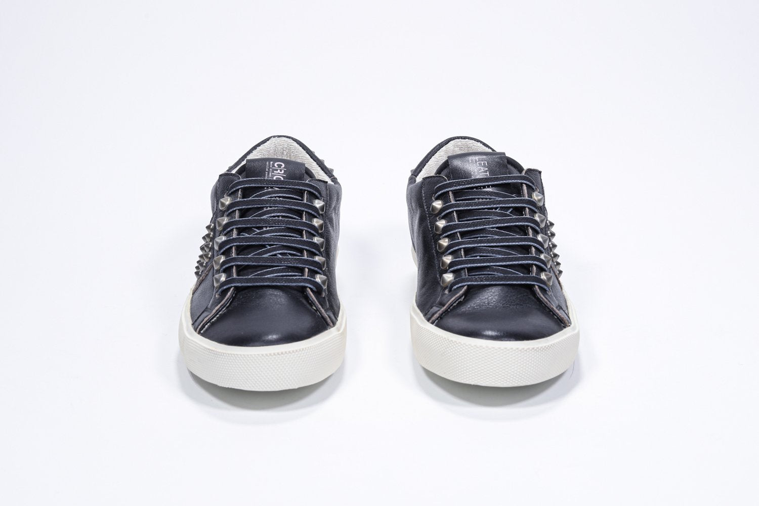 Vue de face de la chaussure noire sneaker. Tige en cuir avec clous et semelle en caoutchouc vintage.