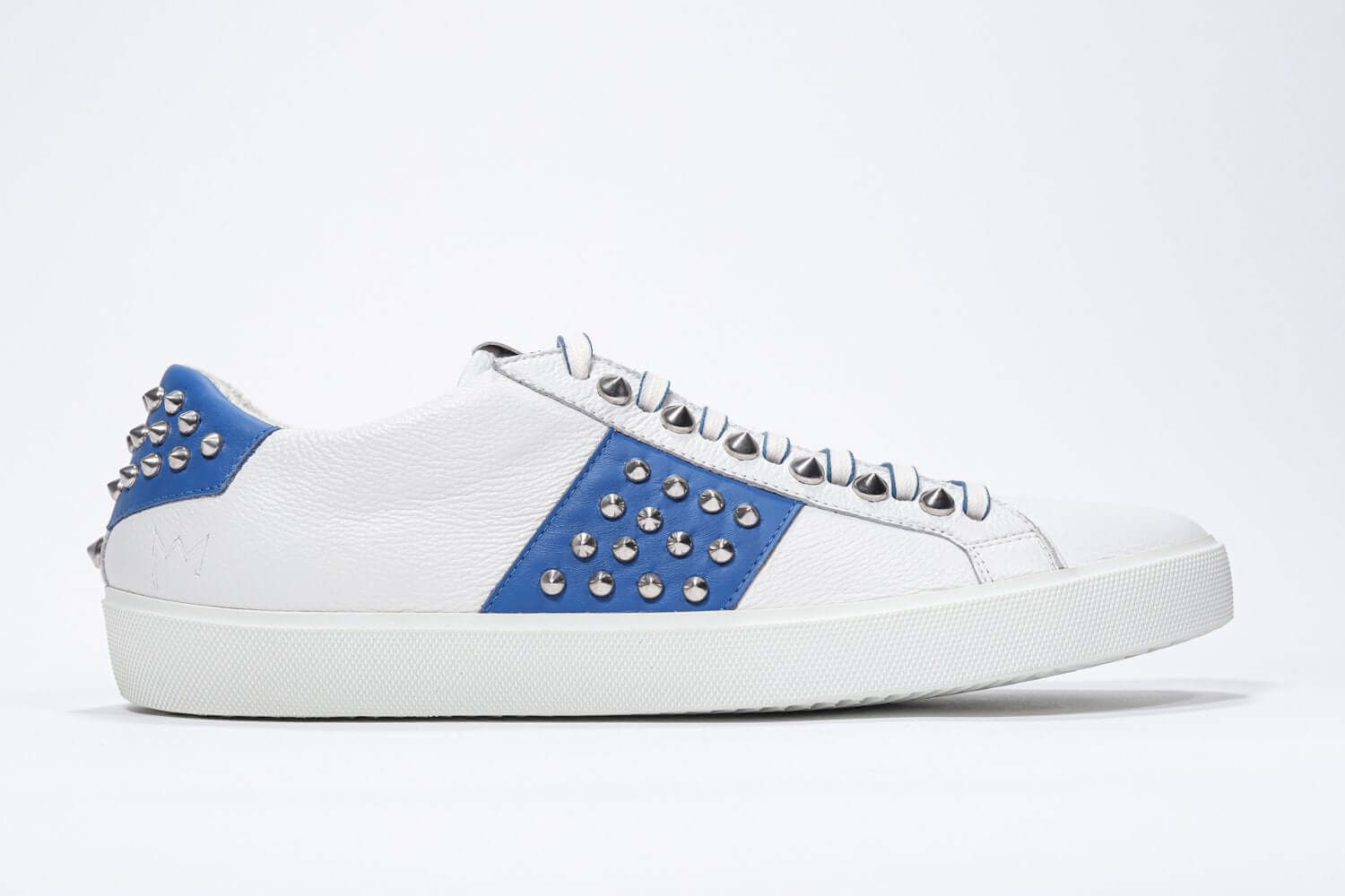 Side profile of low top white and blue sneaker. Full grain leather upper with silver studs and white rubber sole.