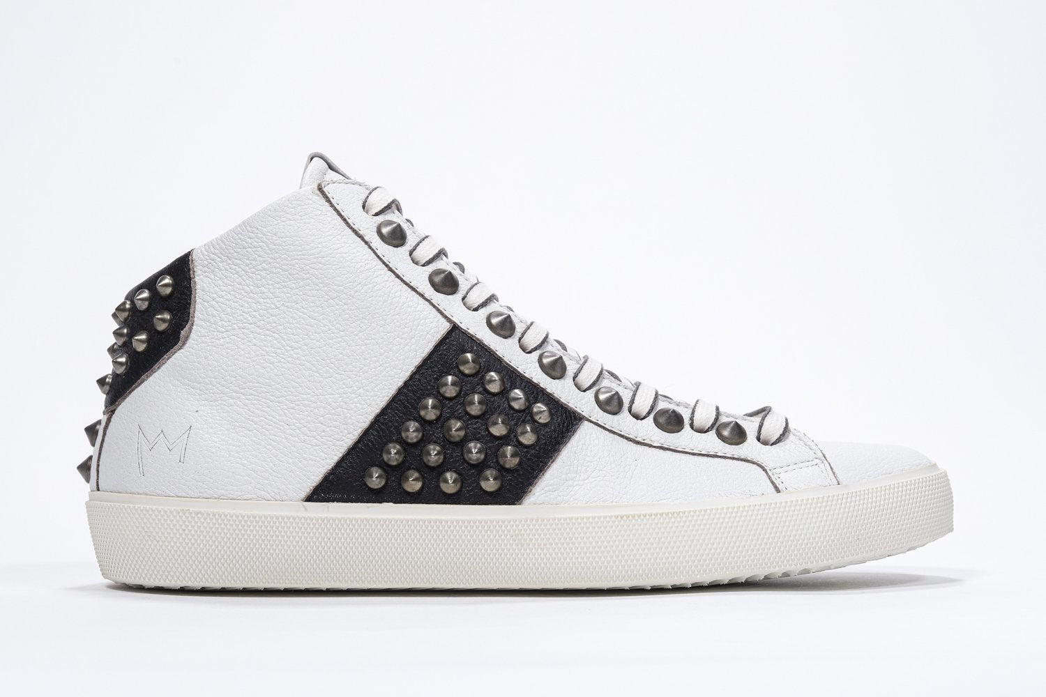 Seitenprofil von Mid Top weiß und schwarz sneaker. Obermaterial aus Vollleder mit Nieten, einem internen Reißverschluss und einer Vintage-Gummisohle.