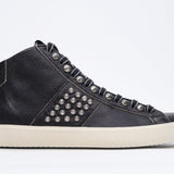 Side profile of mid top black sneaker. Full leather upper with studs, an internal zip and vintage rubber sole.