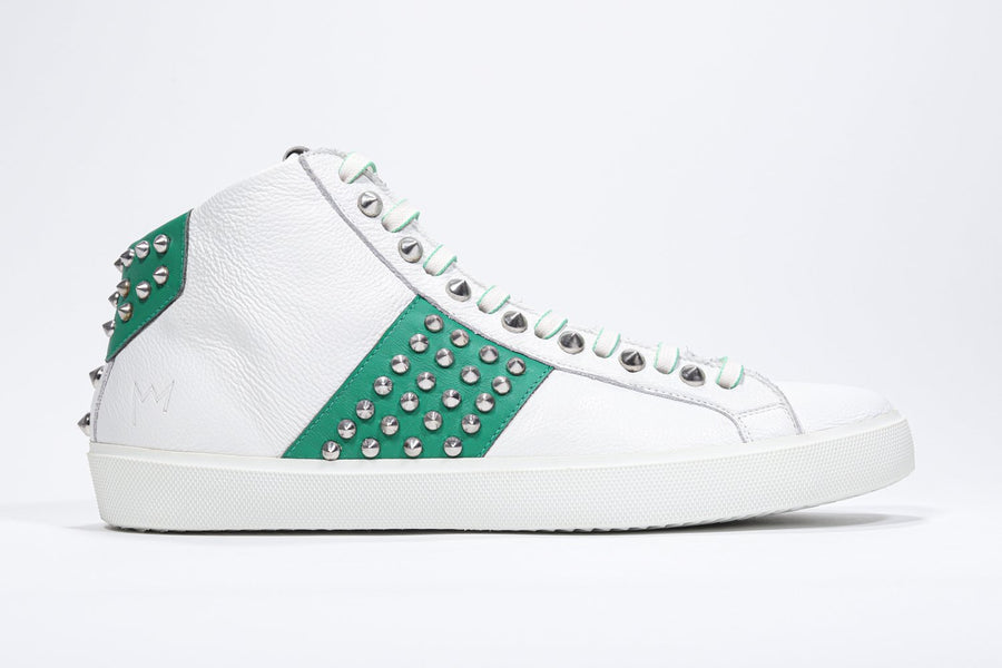 Side profile of mid top white and green sneaker. Full leather upper with studs, an internal zip and white rubber sole.
