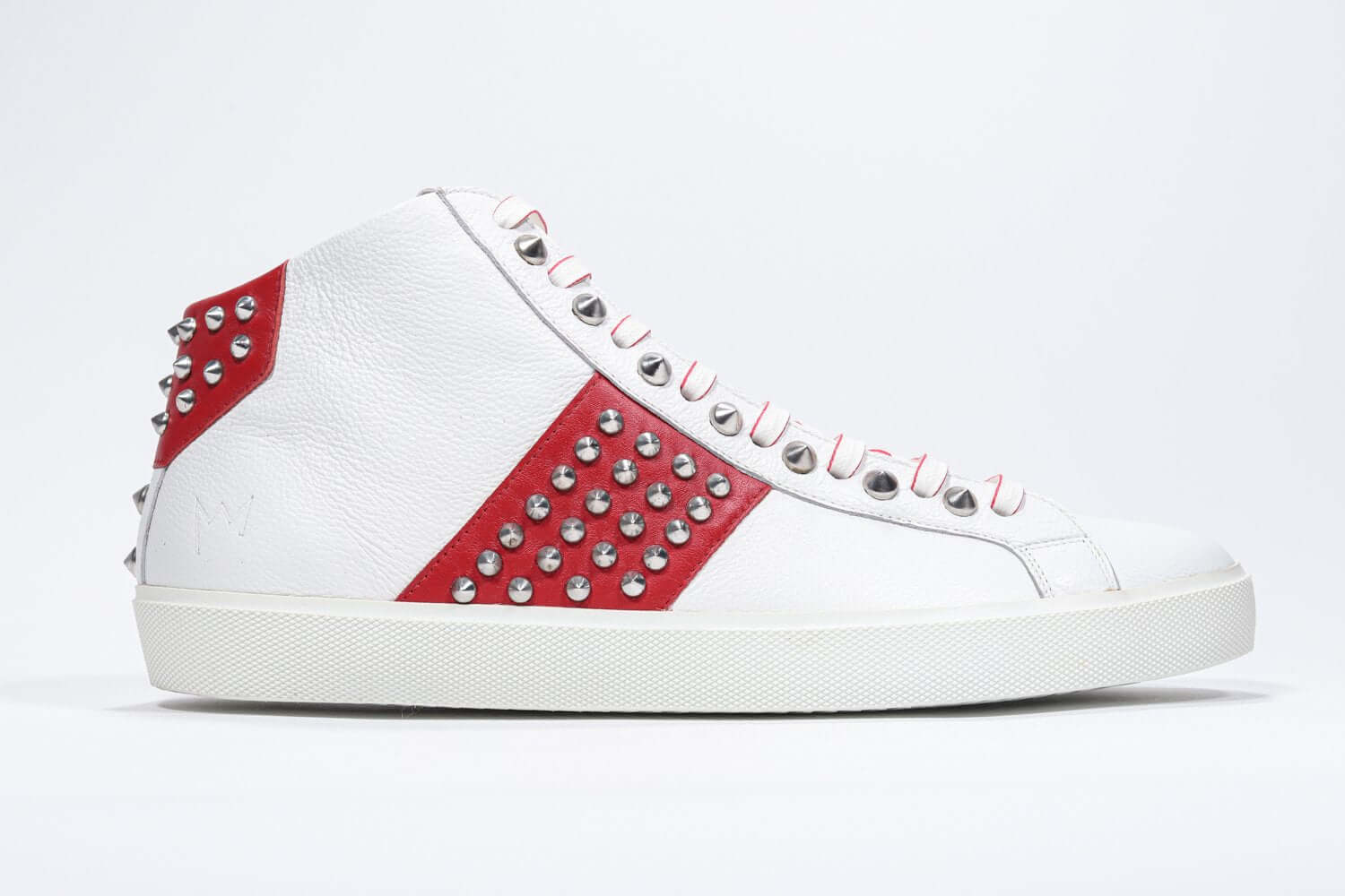 Side profile of mid top white and red sneaker. Full leather upper with studs, an internal zip and white rubber sole.