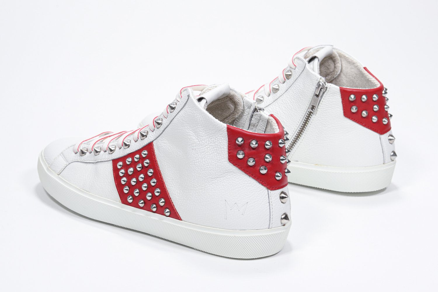 Vue de trois quarts arrière d'un modèle intermédiaire blanc et rouge sneaker. Tige en cuir avec clous, fermeture à glissière interne et semelle en caoutchouc blanc.