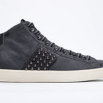 Side profile of mid top navy sneaker. Suede and leather upper with studs, an internal zip and vintage rubber sole.