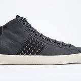Side profile of mid top navy sneaker. Suede and leather upper with studs, an internal zip and vintage rubber sole.
