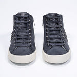 Front view of mid top navy sneaker. Suede and leather upper with studs, an internal zip and vintage rubber sole.
