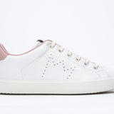 Side profile of low top white sneaker with pale pink detailing and perforated crown logo on upper. Full leather upper and white rubber sole.