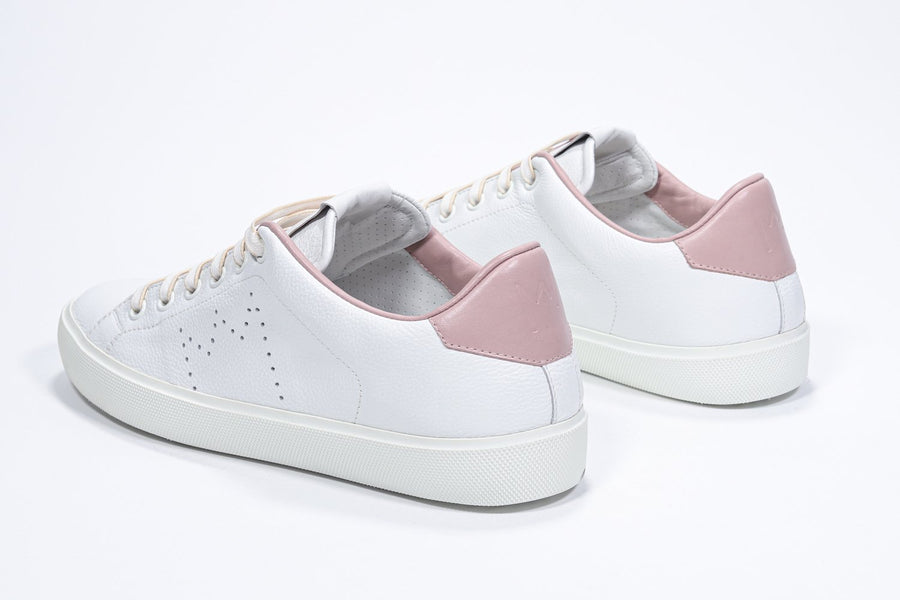 Three quarter back view of low top white sneaker with pale pink detailing and perforated crown logo on upper. Full leather upper and white rubber sole.