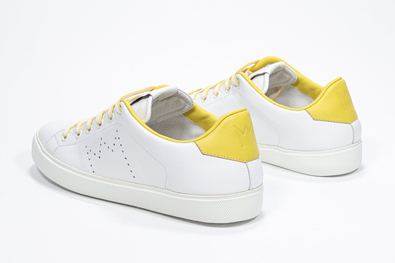 Vue de trois quarts arrière de la chaussure blanche sneaker avec des détails jaunes et le logo perforé de la couronne sur la tige. Tige en cuir et semelle en caoutchouc blanc.