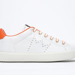 Side profile of low top white sneaker with orange detailing and perforated crown logo on upper. Full leather upper and white rubber sole.