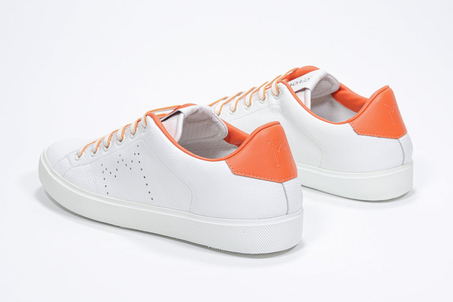 Three quarter back view of low top white sneaker with orange detailing and perforated crown logo on upper. Full leather upper and white rubber sole.