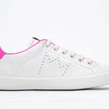 Profilo laterale di BASSE bianco sneaker con dettagli rosa neon e logo della corona traforato sulla tomaia. Tomaia in pelle e suola in gomma bianca.