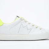 Profilo laterale di BASSE  sneaker  bianco con dettagli giallo neon e logo della corona traforato sulla tomaia. Tomaia in pelle e suola in gomma bianca.