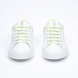 Front front view of low top white sneaker with neon yellow detailing and perforated crown logo on upper. Full leather upper and white rubber sole.