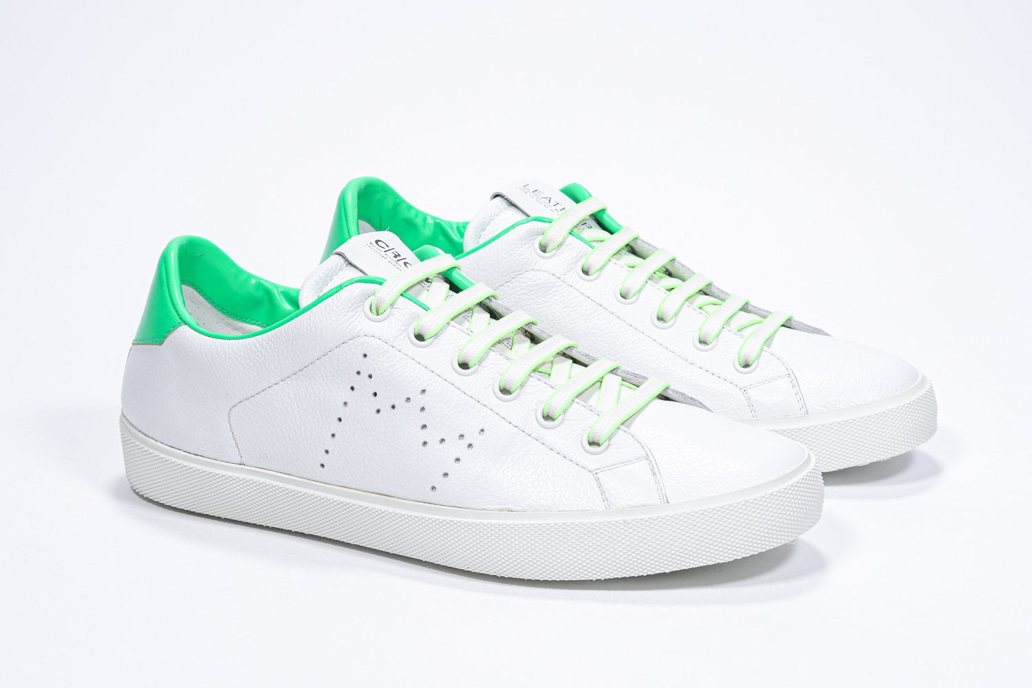 Vue de trois quarts avant de la chaussure basse blanche sneaker avec des détails vert fluo et le logo perforé de la couronne sur la tige. Tige en cuir et semelle en caoutchouc blanc.