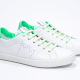 Three quarter front view of low top white sneaker with neon green detailing and perforated crown logo on upper. Full leather upper and white rubber sole.