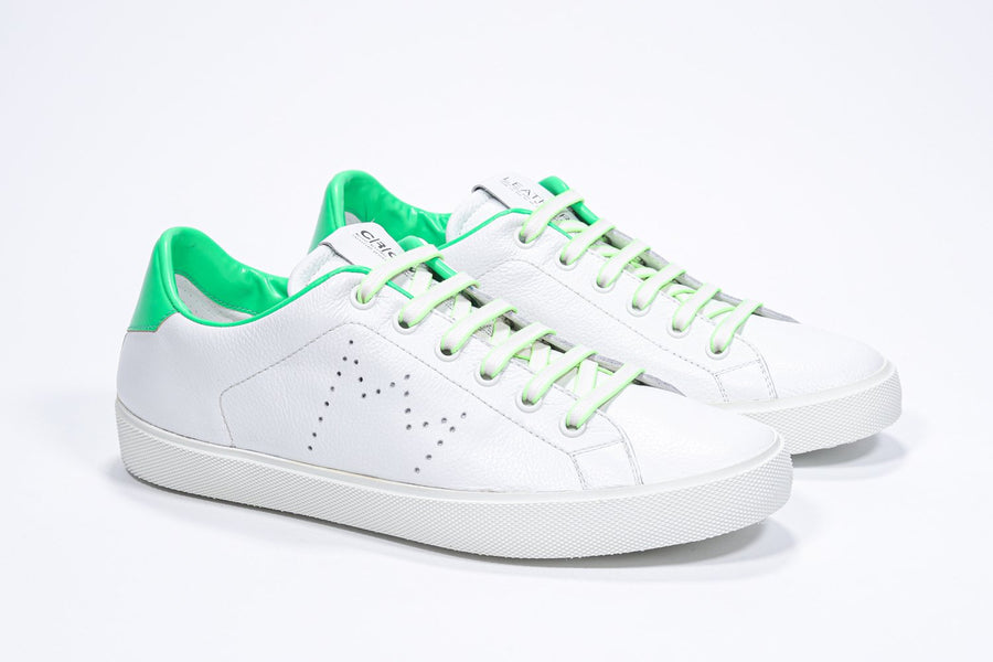 Three quarter front view of low top white sneaker with neon green detailing and perforated crown logo on upper. Full leather upper and white rubber sole.