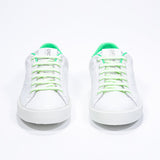 Front view of low top white sneaker with neon green detailing and perforated crown logo on upper. Full leather upper and white rubber sole.