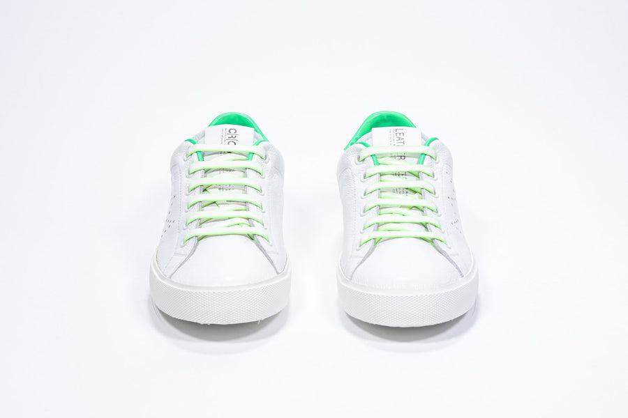 Front view of low top white sneaker with neon green detailing and perforated crown logo on upper. Full leather upper and white rubber sole.