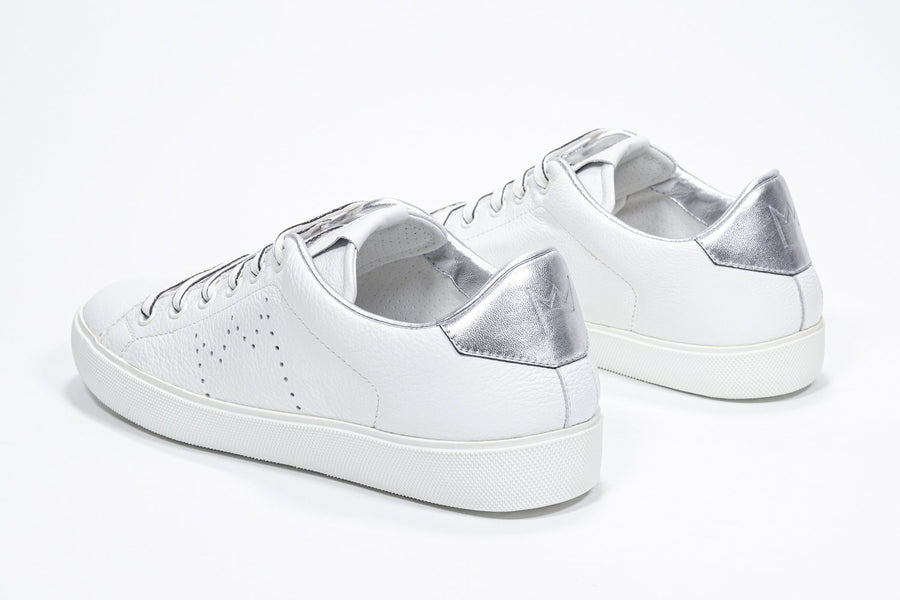 Three quarter back view of low top white sneaker with silver detailing and perforated crown logo on upper. Full leather upper and white rubber sole.