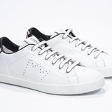 Three quarter front view of low top white sneaker with leopard print detailing and perforated crown logo on upper. Full leather upper and white rubber sole.