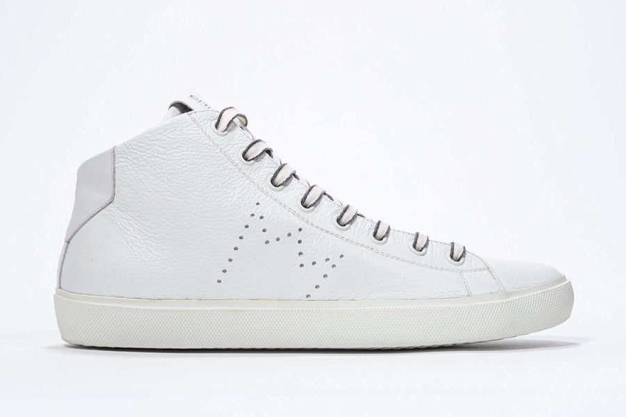 Side profile of mid top white sneaker with full leather upper with perforated crown logo, internal zip and white sole.