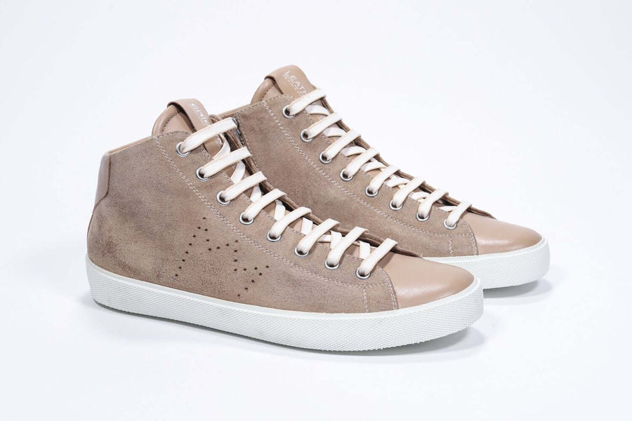 Three quarter front view of mid top cuoio sneaker with full suede upper with perforated crown logo, internal zip and white sole.