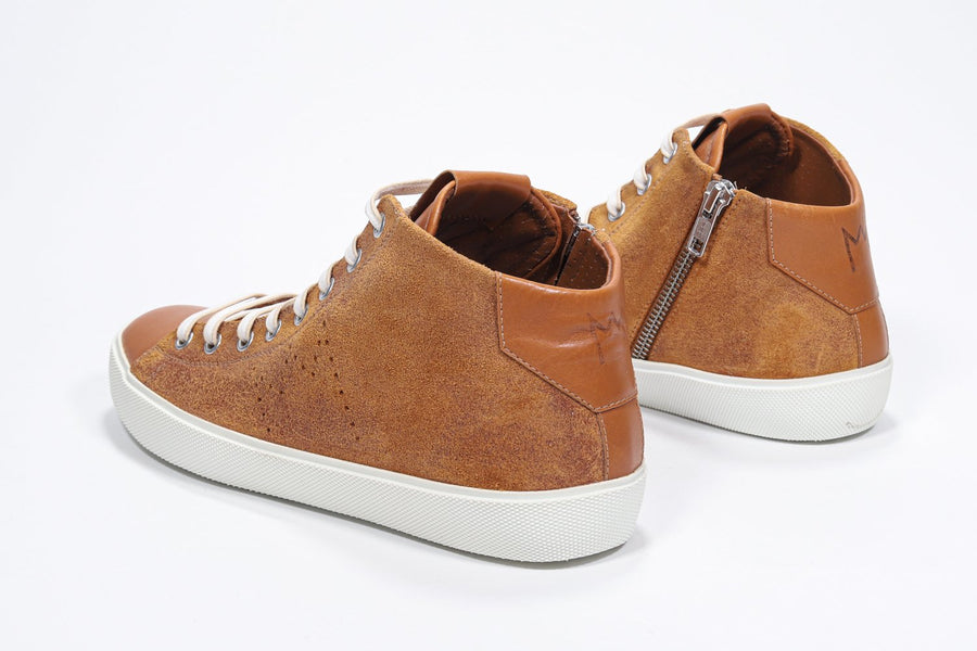 Three quarter back view of mid top rust sneaker with full suede upper with perforated crown logo, internal zip and white sole.