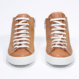 Front of mid top rust sneaker with full suede upper with perforated crown logo, internal zip and white sole.