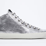 Side profile of mid top silver sneaker with full leather upper with perforated crown logo, internal zip and white sole.