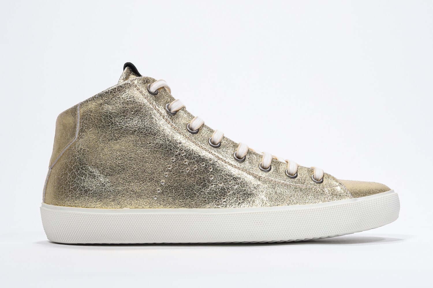 Side profile of mid top gold sneaker with full leather upper with perforated crown logo, internal zip and white sole.