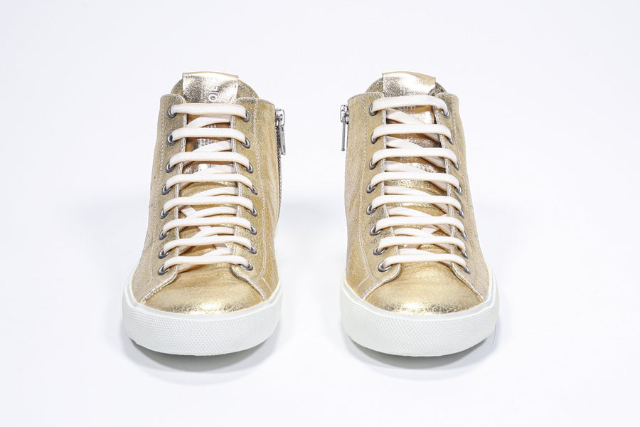 Front view of mid top gold sneaker with full leather upper with perforated crown logo, internal zip and white sole.